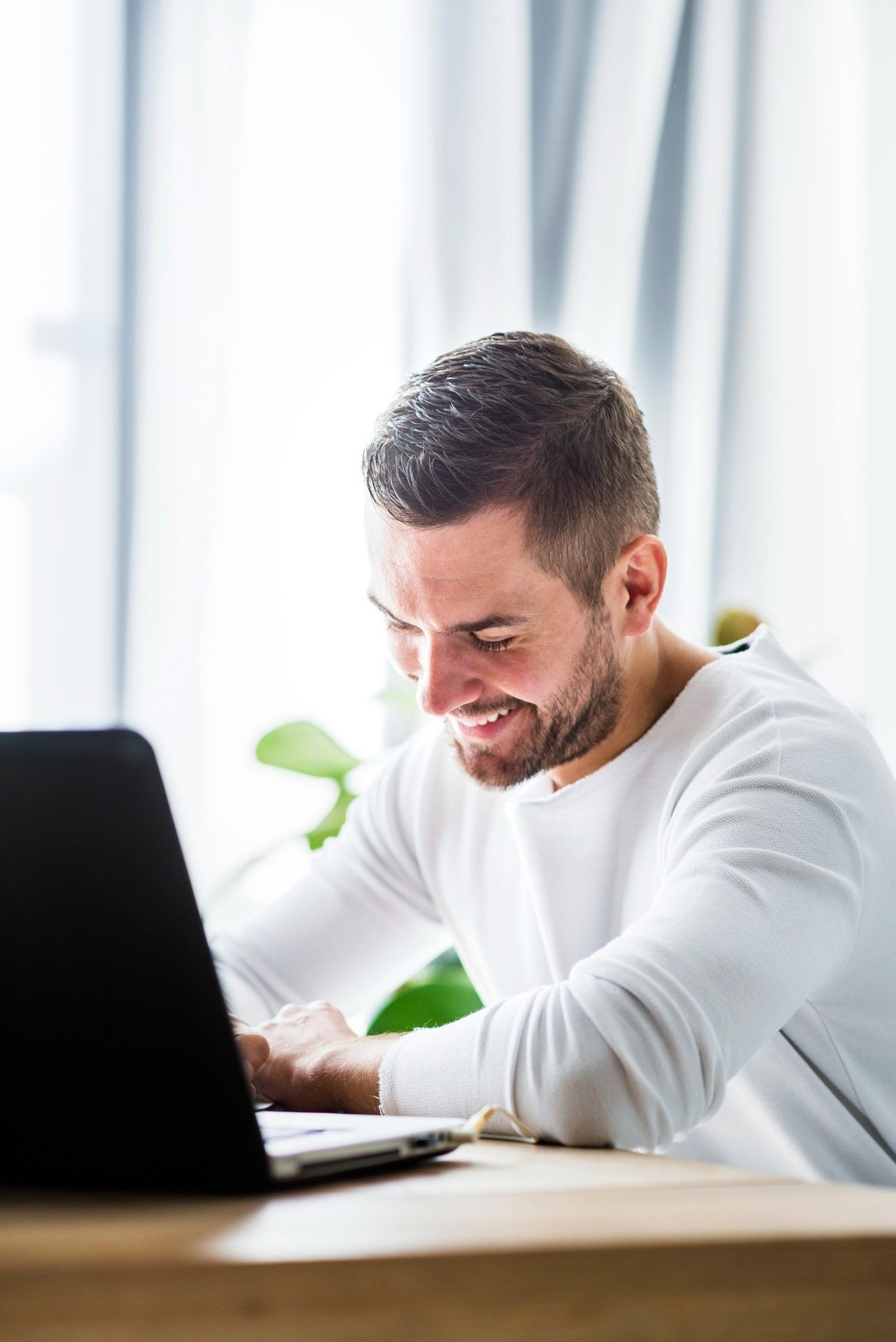 Man smiling at laptop screen